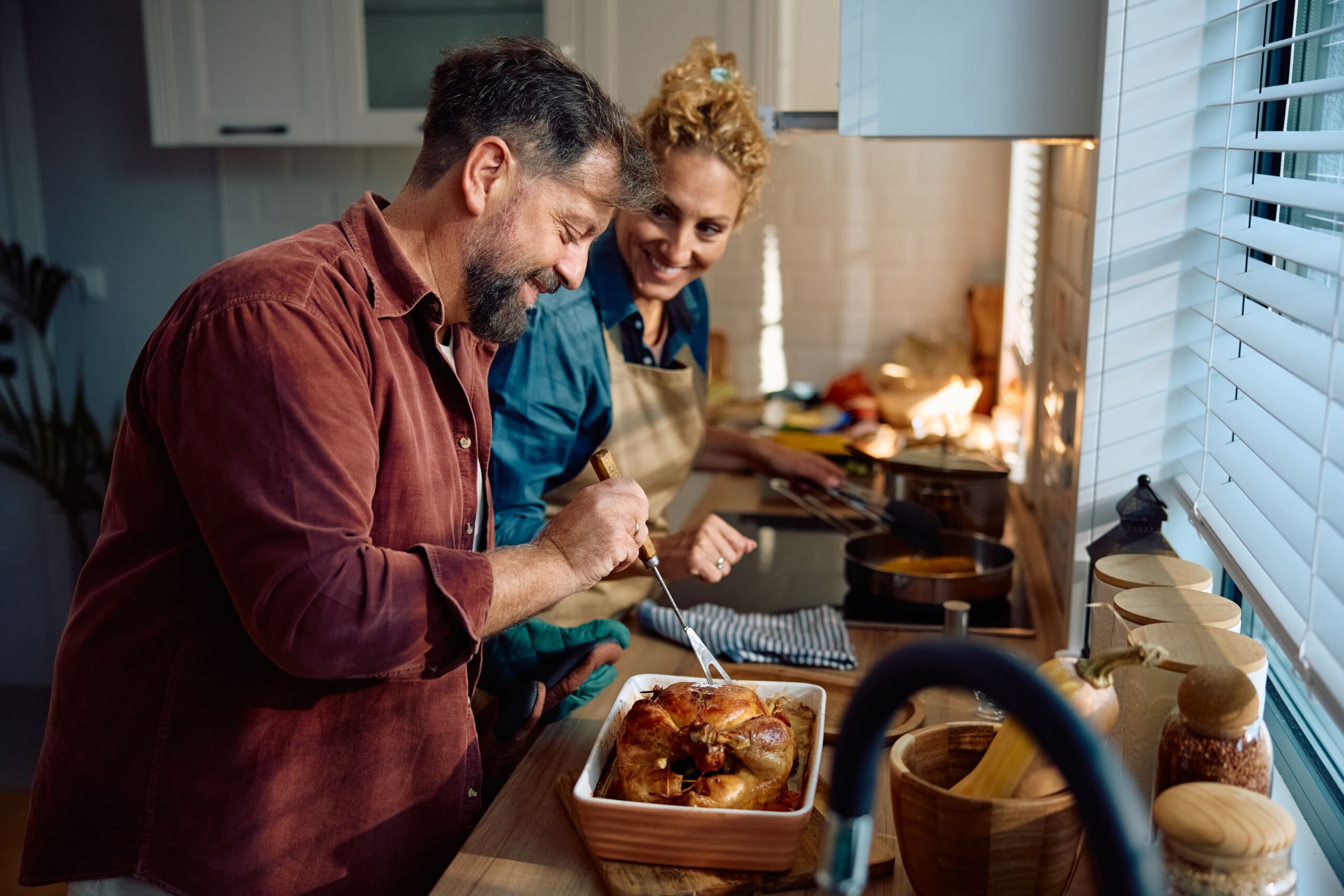 Happy,Man,And,His,Wife,Preparing,Roast,Turkey,For,Thanksgiving